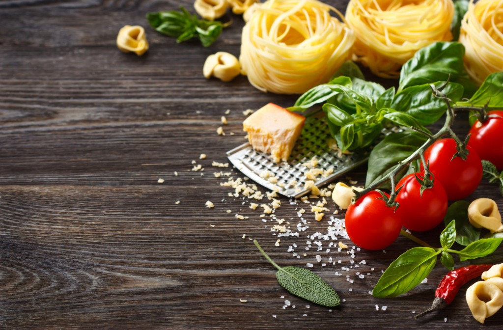 Italian food ingredients for cooking pasta on a wooden background with copy space.