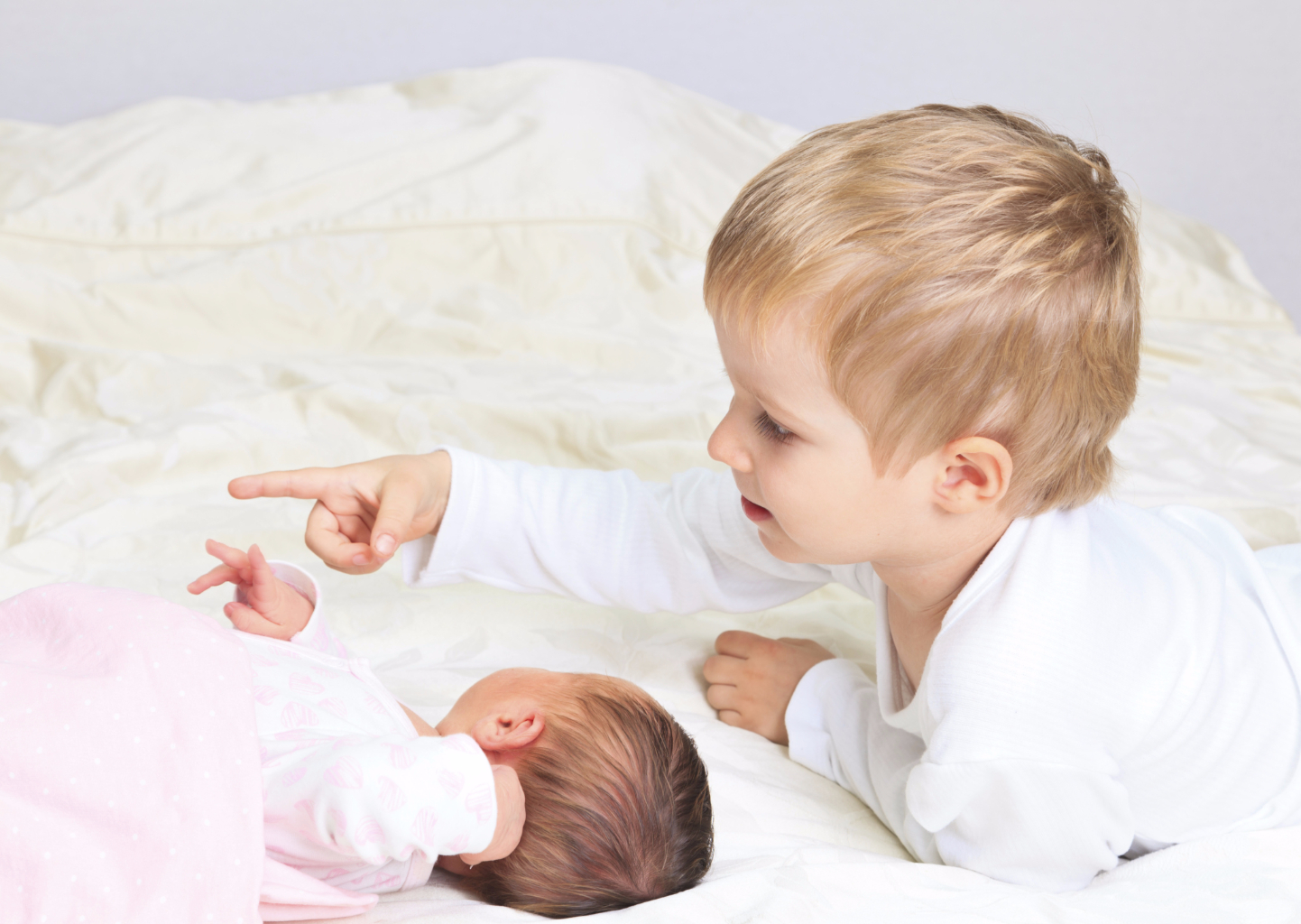 little boy playing with newborn sister, family love and care